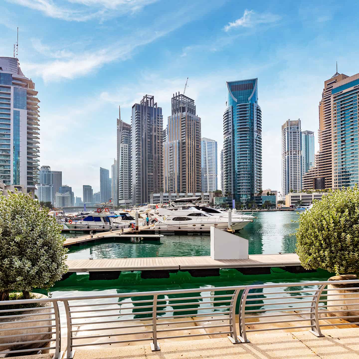 Stunning Dubai cityscape featuring high-rise buildings and yacht-filled marina in UAE.