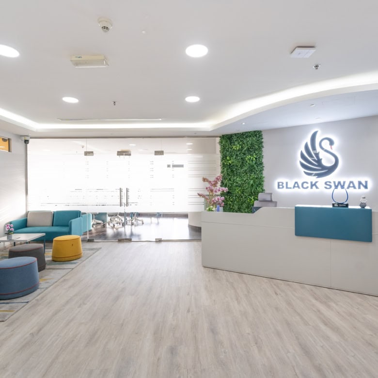 Bright, welcoming lobby with contemporary design, green wall, and Black Swan branding, ideal for startups and entrepreneurs.
