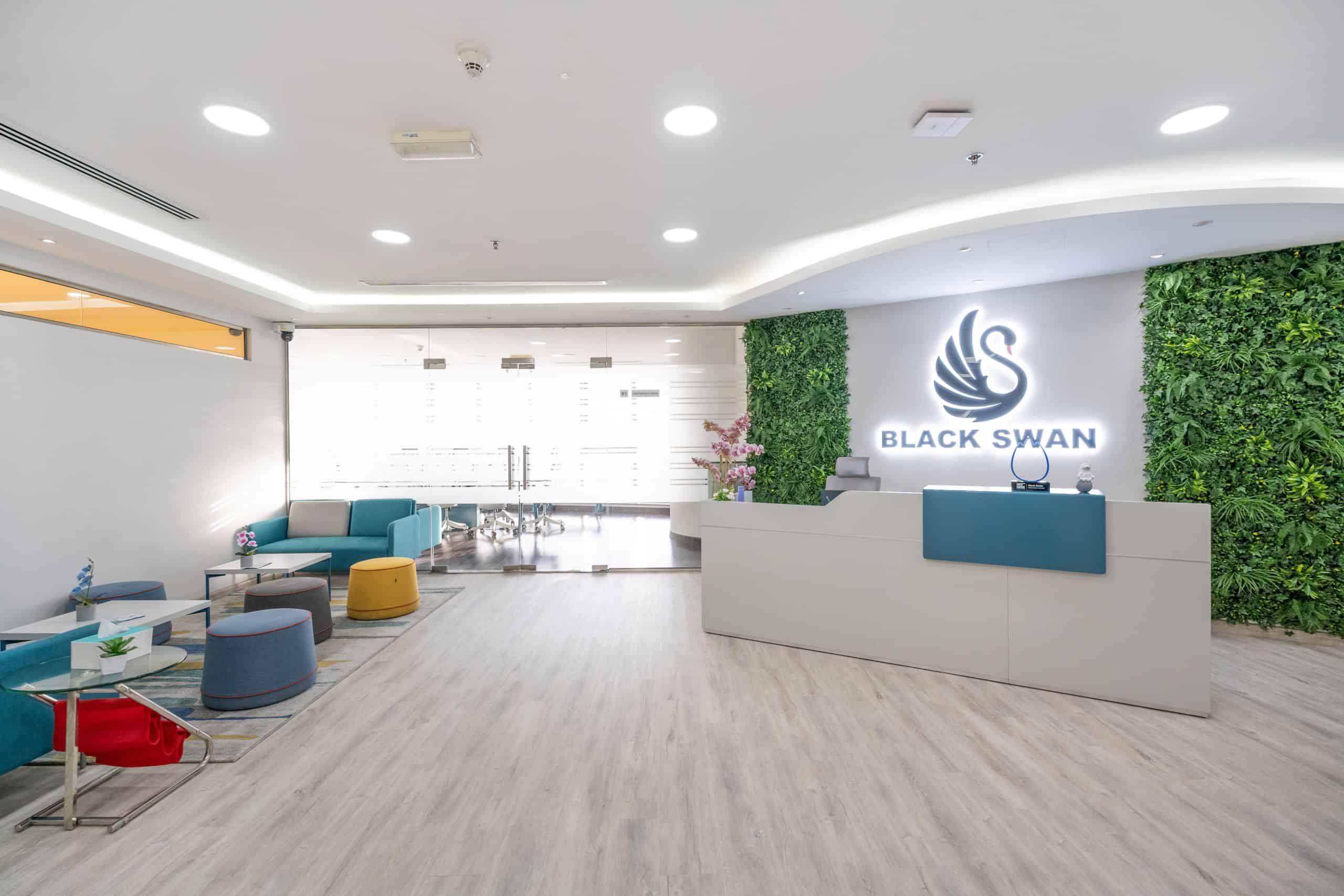 Bright, welcoming lobby with contemporary design, green wall, and Black Swan branding, ideal for startups and entrepreneurs.