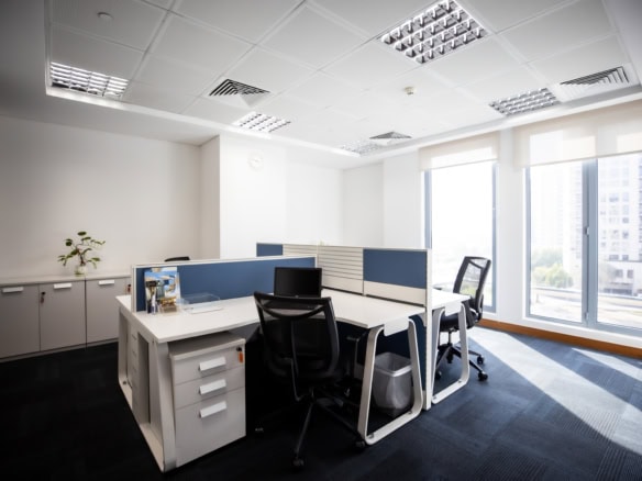 Bright coworking office with desk setup, large windows, and natural light in UAE.