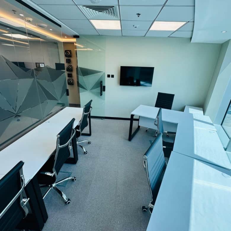 Bright Dubai office with large windows, modern desks, and tech setup for remote work.
