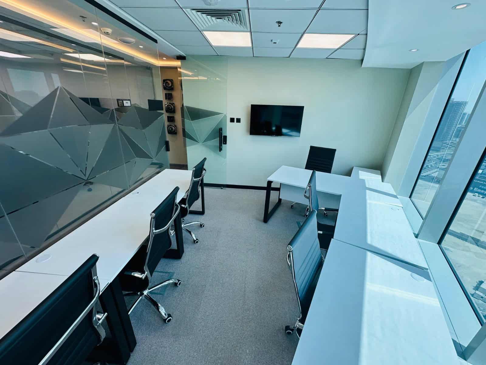 Bright Dubai office with large windows, modern desks, and tech setup for remote work.
