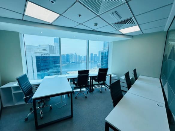 Bright, spacious UAE office with large windows, seating for team collaboration, and contemporary furnishings.