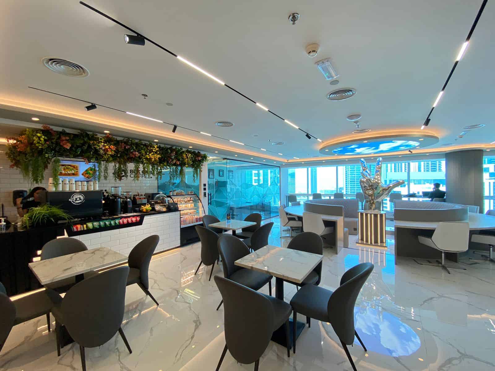 Bright, contemporary workspace at Nextspace UAE with stylish decor, seating areas, and scenic skyline views.