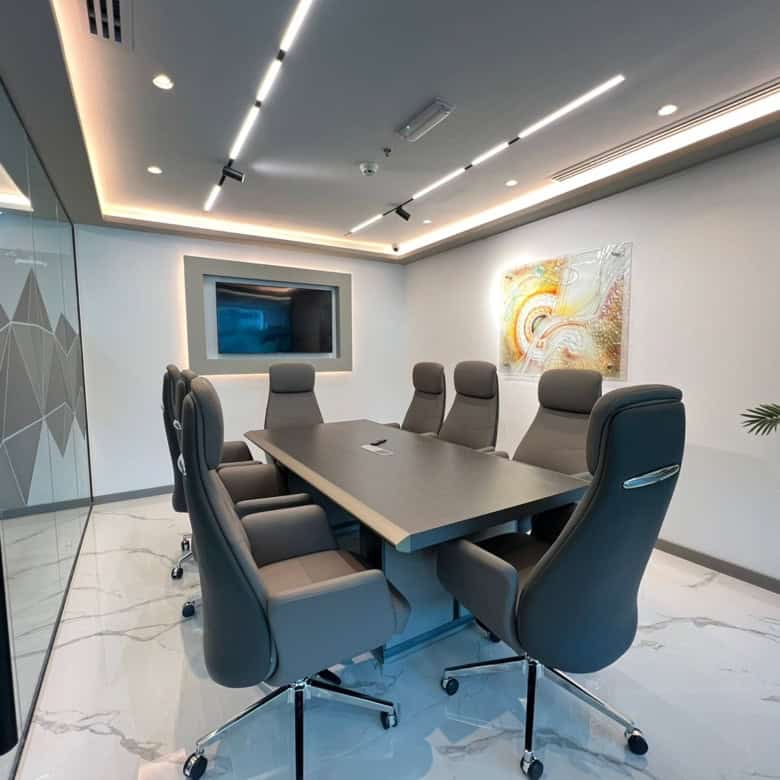 Luxurious conference room with ergonomic chairs, sleek table, and modern art in Dubai.