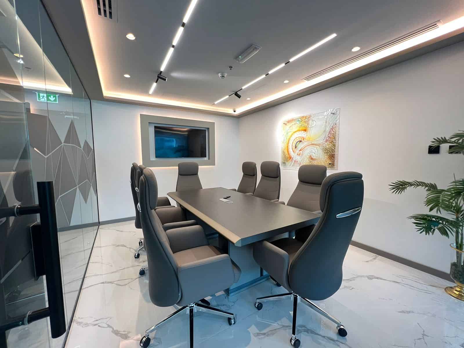 Luxurious conference room with ergonomic chairs, sleek table, and modern art in Dubai.