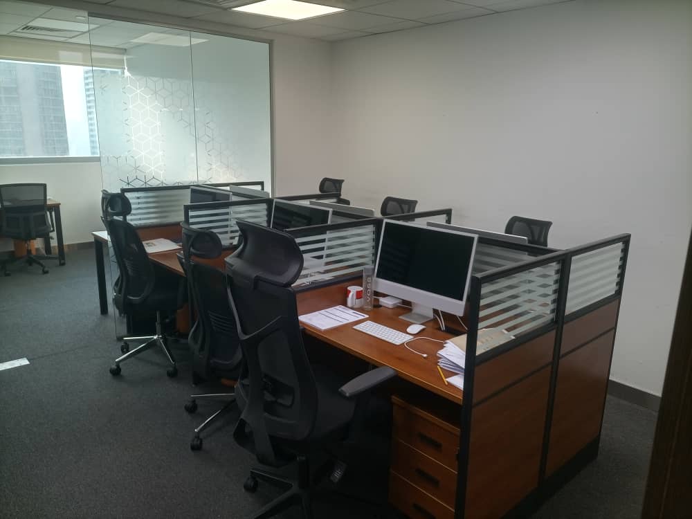 Office desks with computers and ergonomic chairs in a private workspace, ideal for remote working and startups in Dubai.