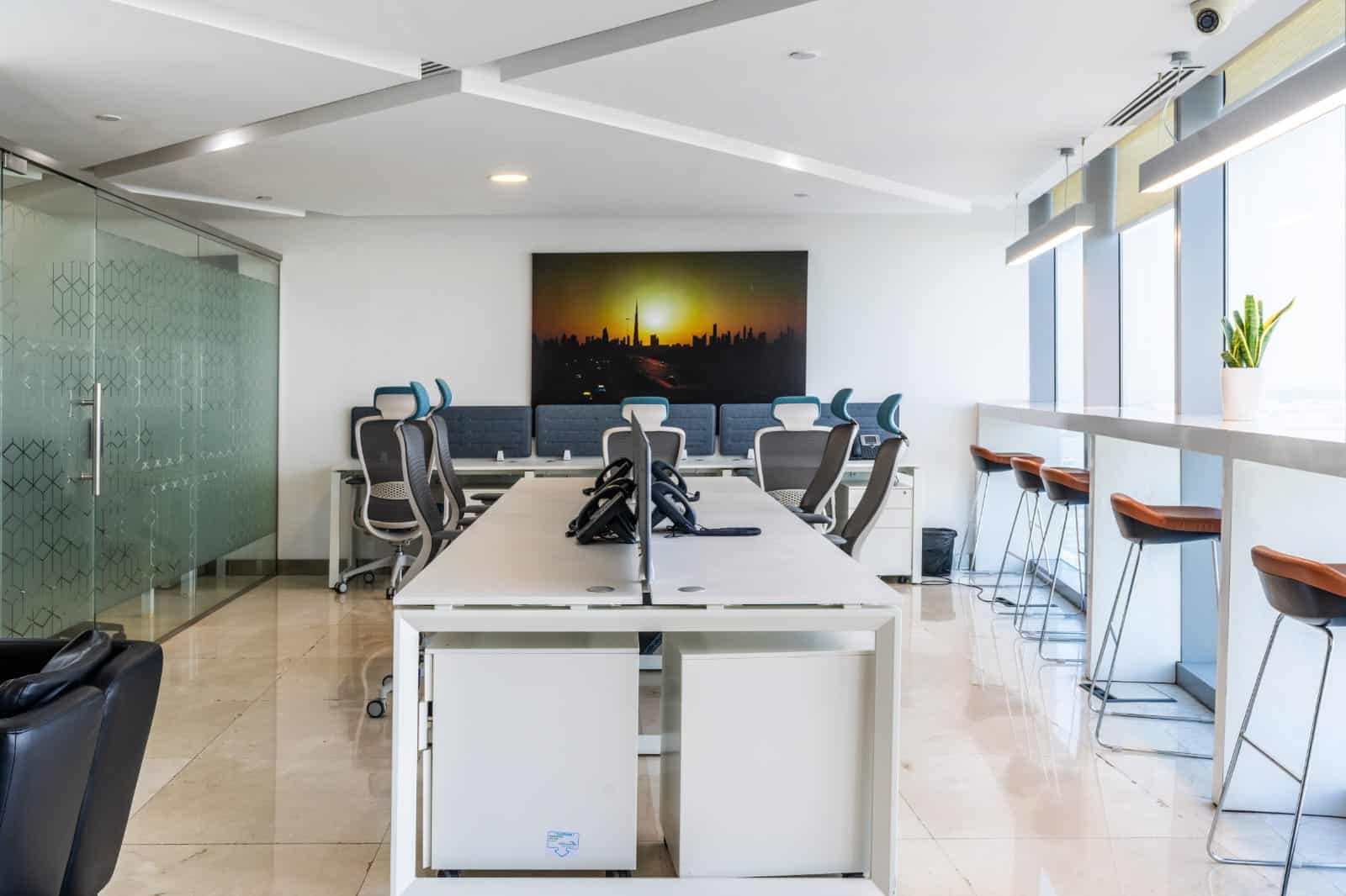 Bright, contemporary Dubai office with ergonomic chairs, meeting area, and skyline view for remote work.