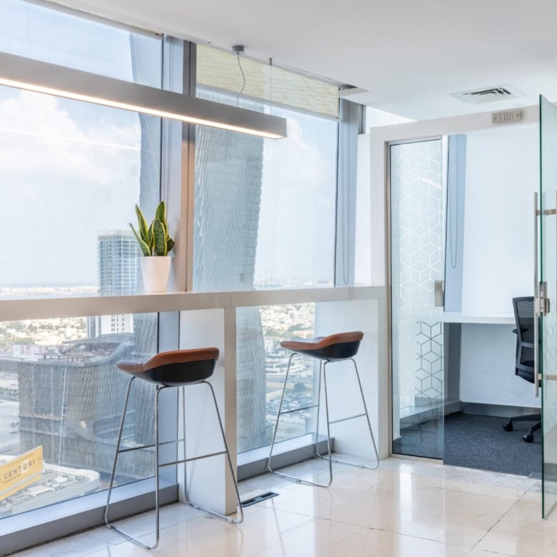 Bright office interior with high-rise skyline views, glass walls, and seating areas at Nextspace UAE.