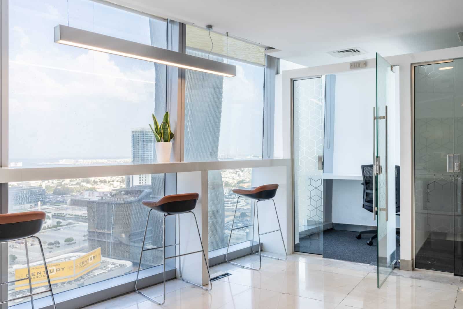 Bright office interior with high-rise skyline views, glass walls, and seating areas at Nextspace UAE.