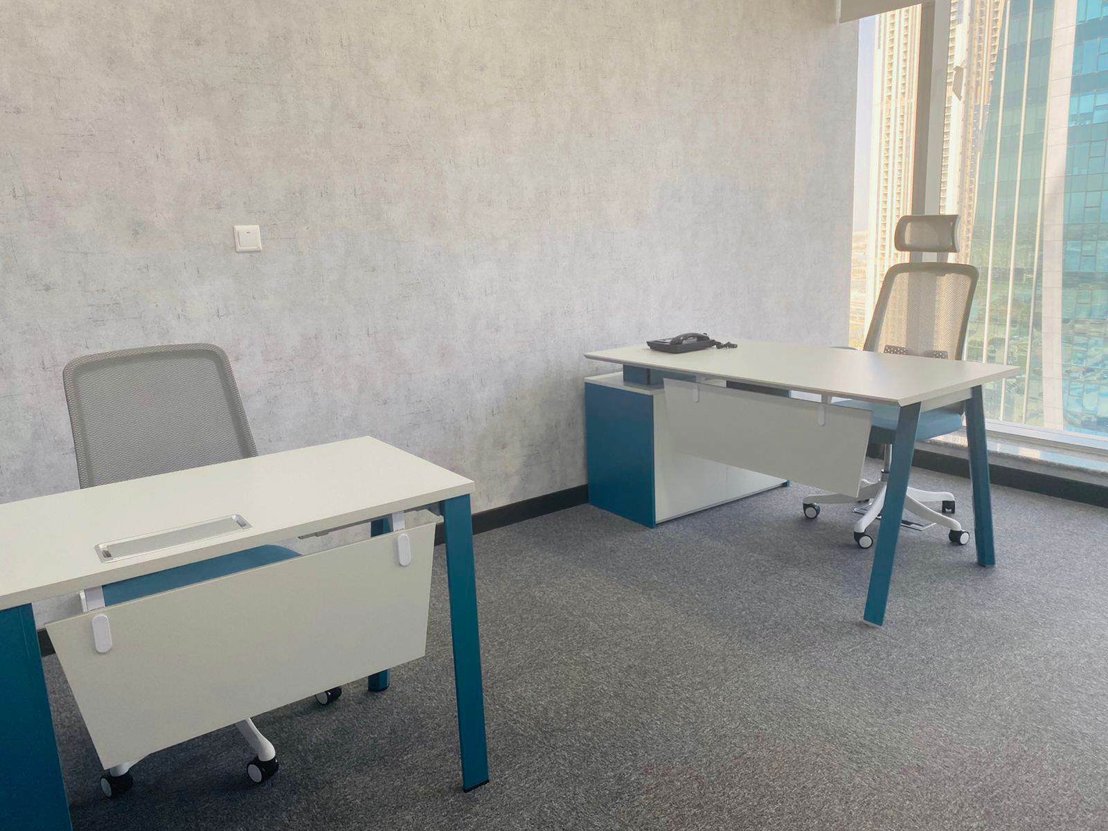 Contemporary coworking workspace near Dubai city skyline with large windows.