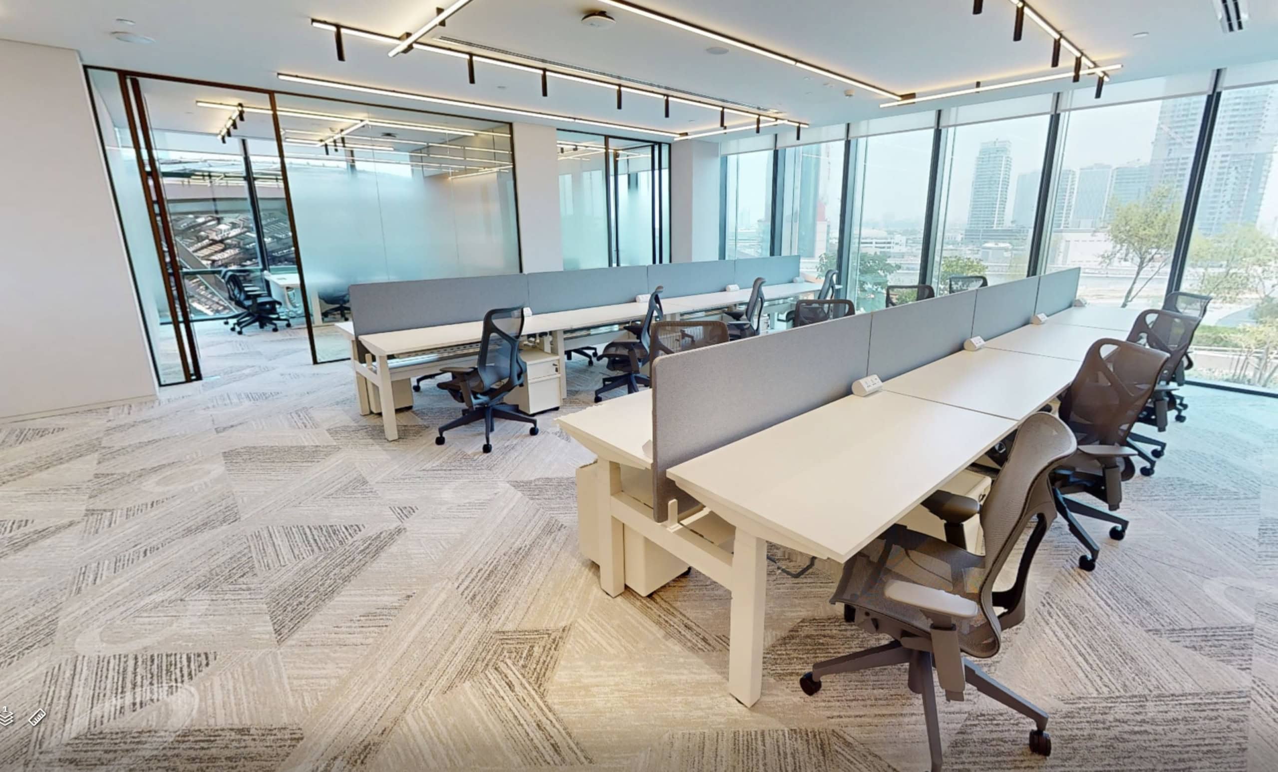 Bright Dubai office with workstations, modern furniture, and city views.