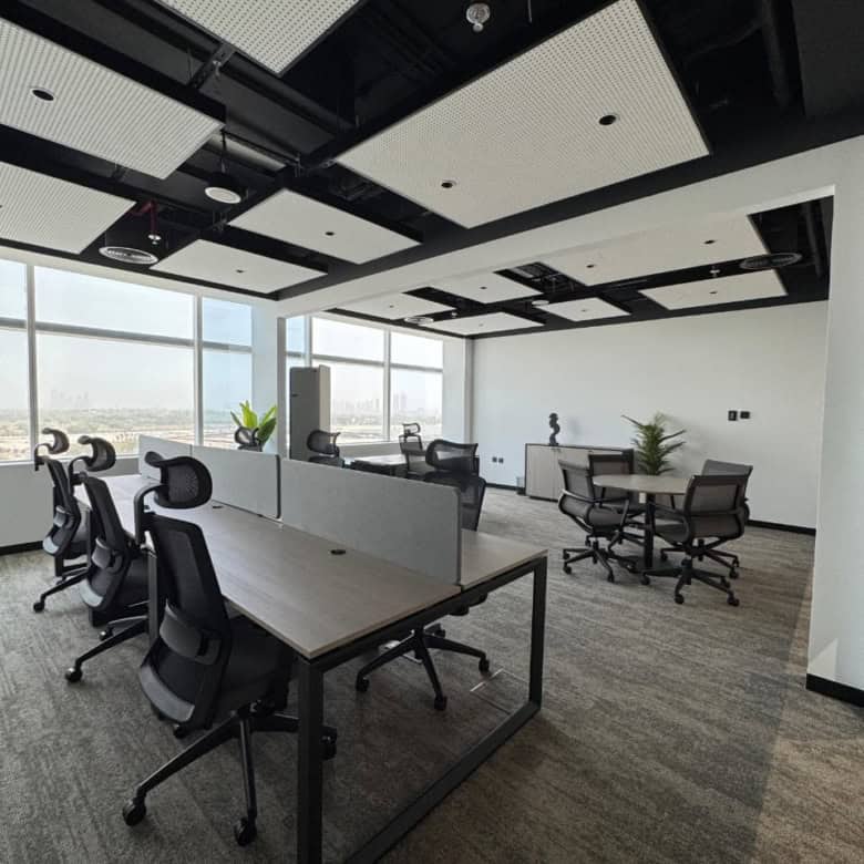 Spacious coworking workspace in Dubai with large windows, modern furniture, and natural light ambiance.