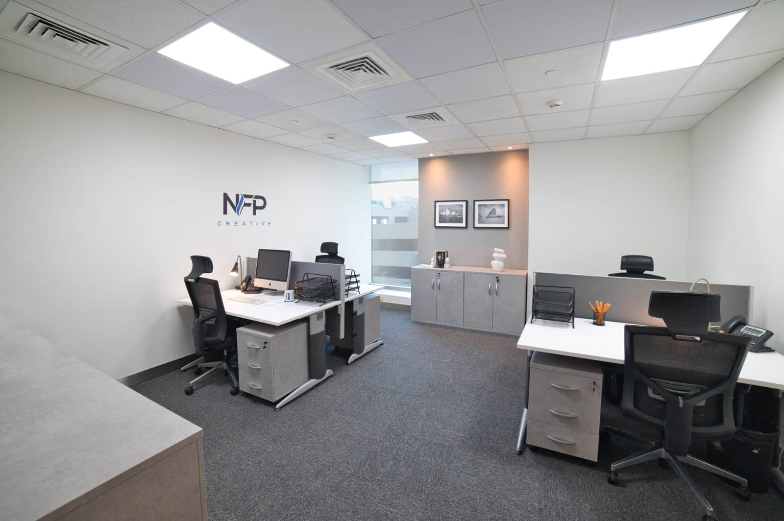 Contemporary office interior with desks, chairs, and modern decor for productive work environment.