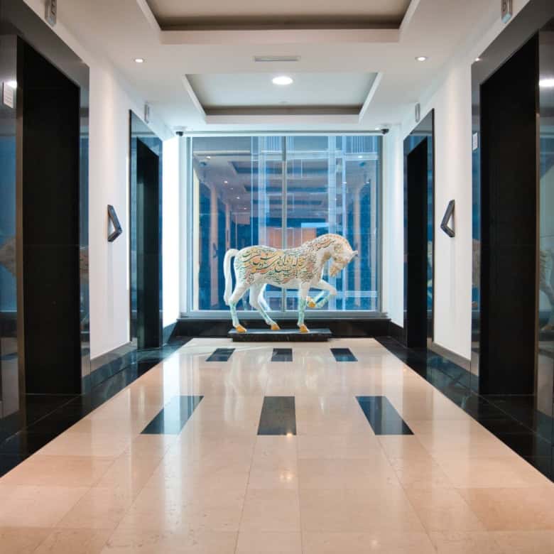 Elevator lobby at Nextspace UAE with sleek design, artwork, and bright lighting.