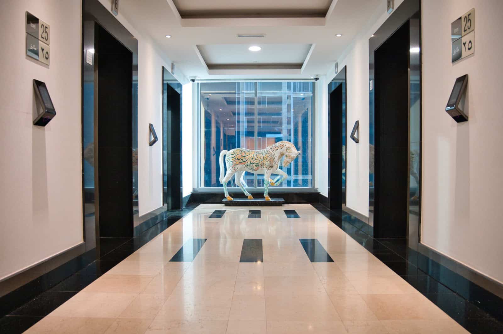 Elevator lobby at Nextspace UAE with sleek design, artwork, and bright lighting.