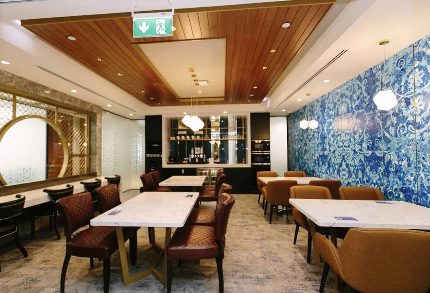 Spacious and stylish coworking restaurant in UAE with modern decor, lounge seating, and vibrant blue accent walls.