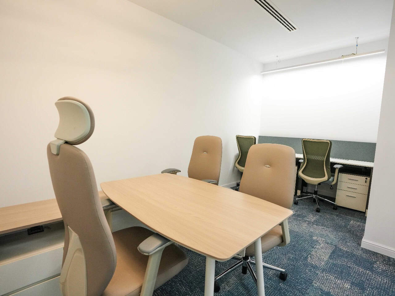 Clean, ergonomic office chairs and a minimalist meeting room setup.