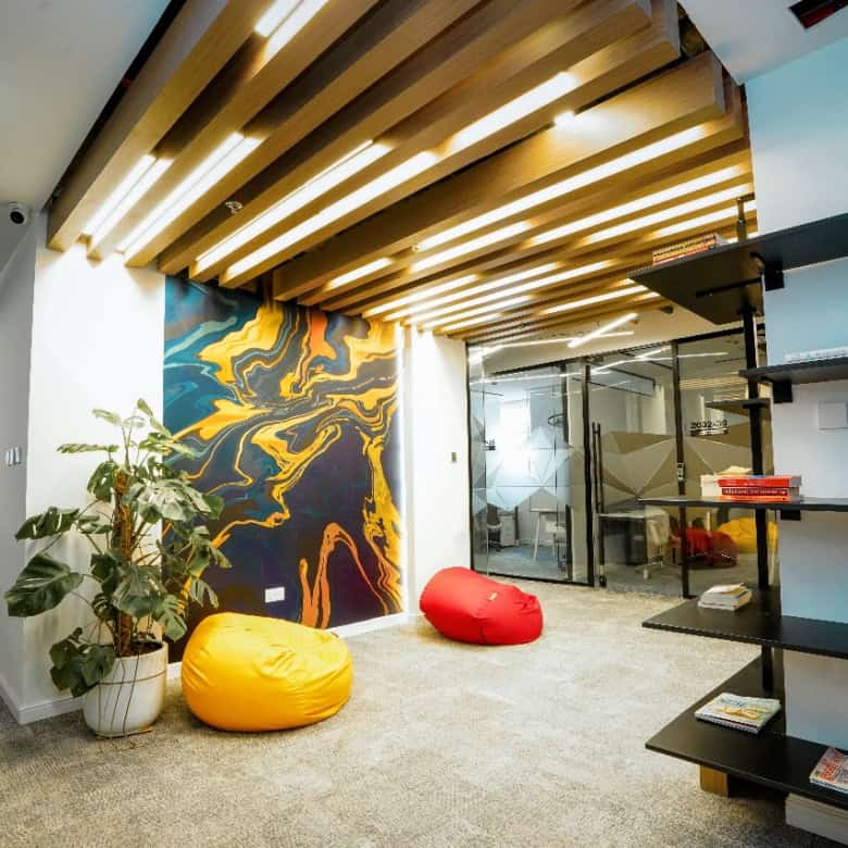 Bright coworking office interior featuring stylish seating, a colorful wall mural, and modern design elements in Dubai.