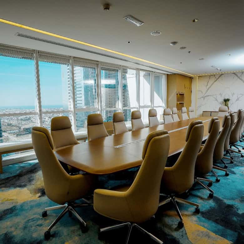 Spacious Dubai office with large windows, ergonomic chairs, and a high-tech conference table for professional gatherings.