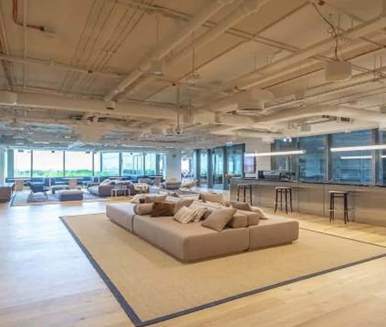 Spacious coworking office in UAE featuring a relaxing lounge and large windows with city views.