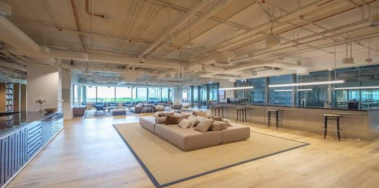 Spacious coworking office in UAE featuring a relaxing lounge and large windows with city views.