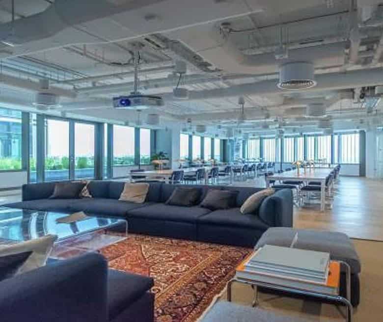 Bright UAE coworking office with lounge, open seating, and large windows.