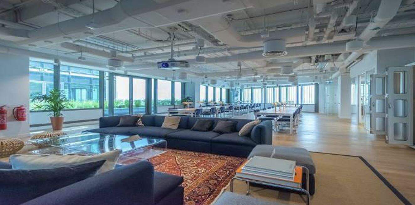Bright UAE coworking office with lounge, open seating, and large windows.