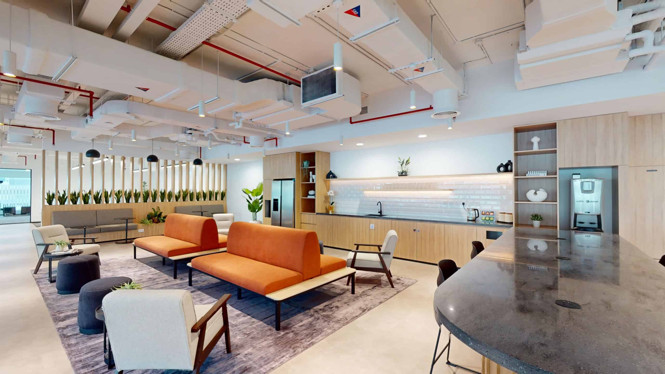 Bright, contemporary coworking environment in UAE featuring cozy seating and a functional kitchen.