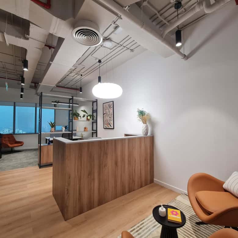 Furnished office lounge with stylish chairs, a reception area, and city view windows, ideal for productivity and networking.