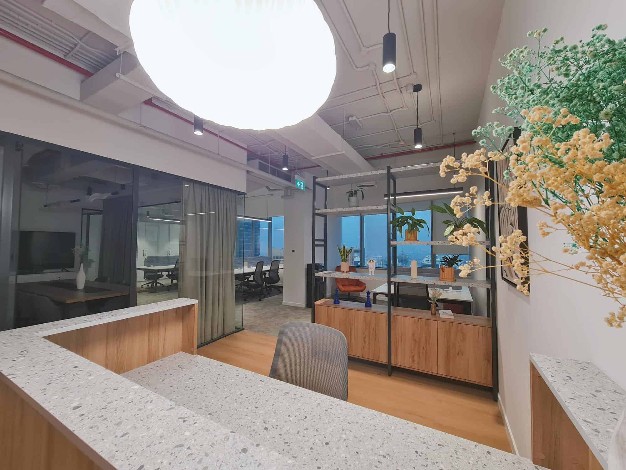 Bright office environment with plants, shelving, and large windows in UAE.