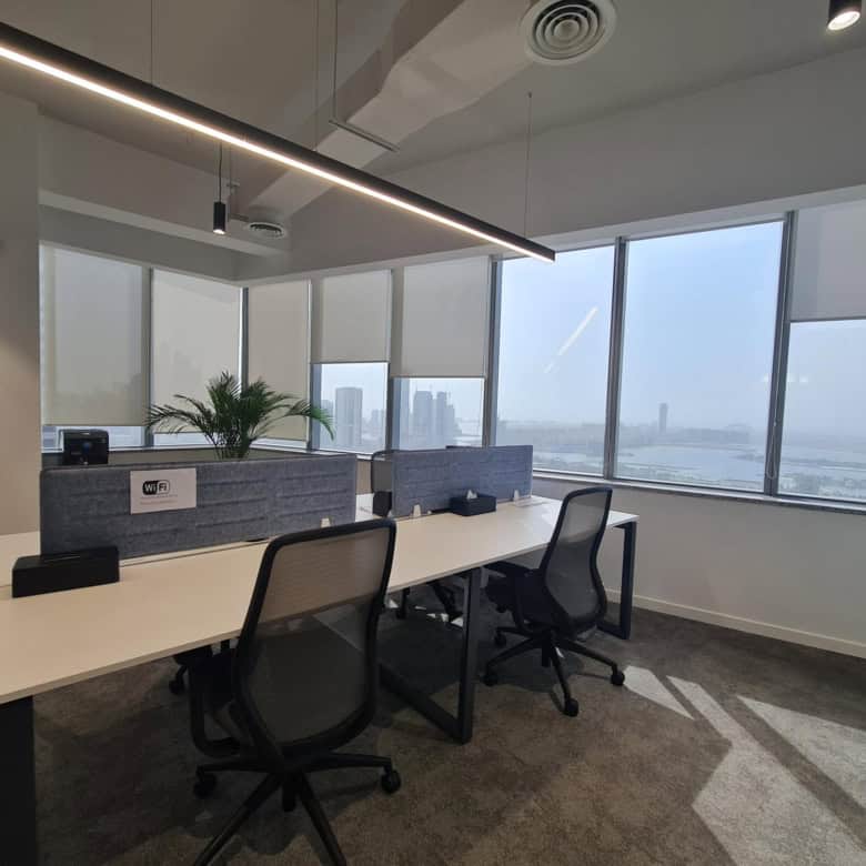 Bright office with large windows, ergonomic chairs, and Wi-Fi at Nextspace UAE coworking space.