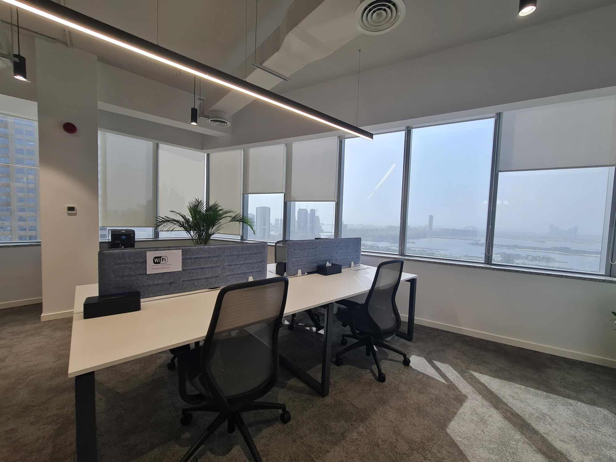 Bright office with large windows, ergonomic chairs, and Wi-Fi at Nextspace UAE coworking space.