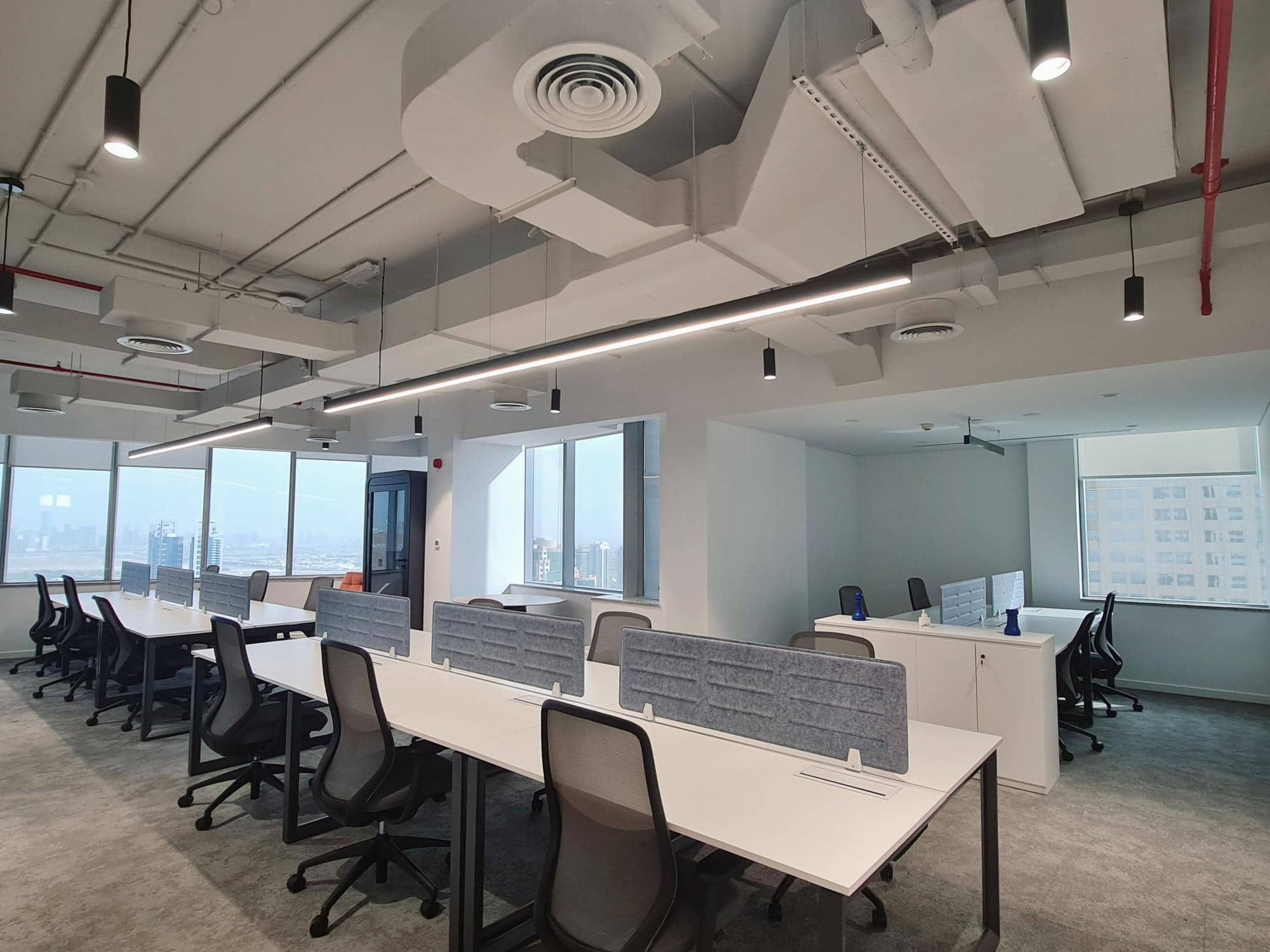 Modern coworking office in Dubai featuring open desks, ergonomic chairs, bright natural light, and modern interior design.