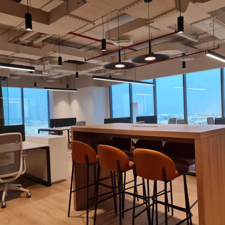 Bright, contemporary workspace with large windows, ergonomic chairs, and stylish lighting for productivity.