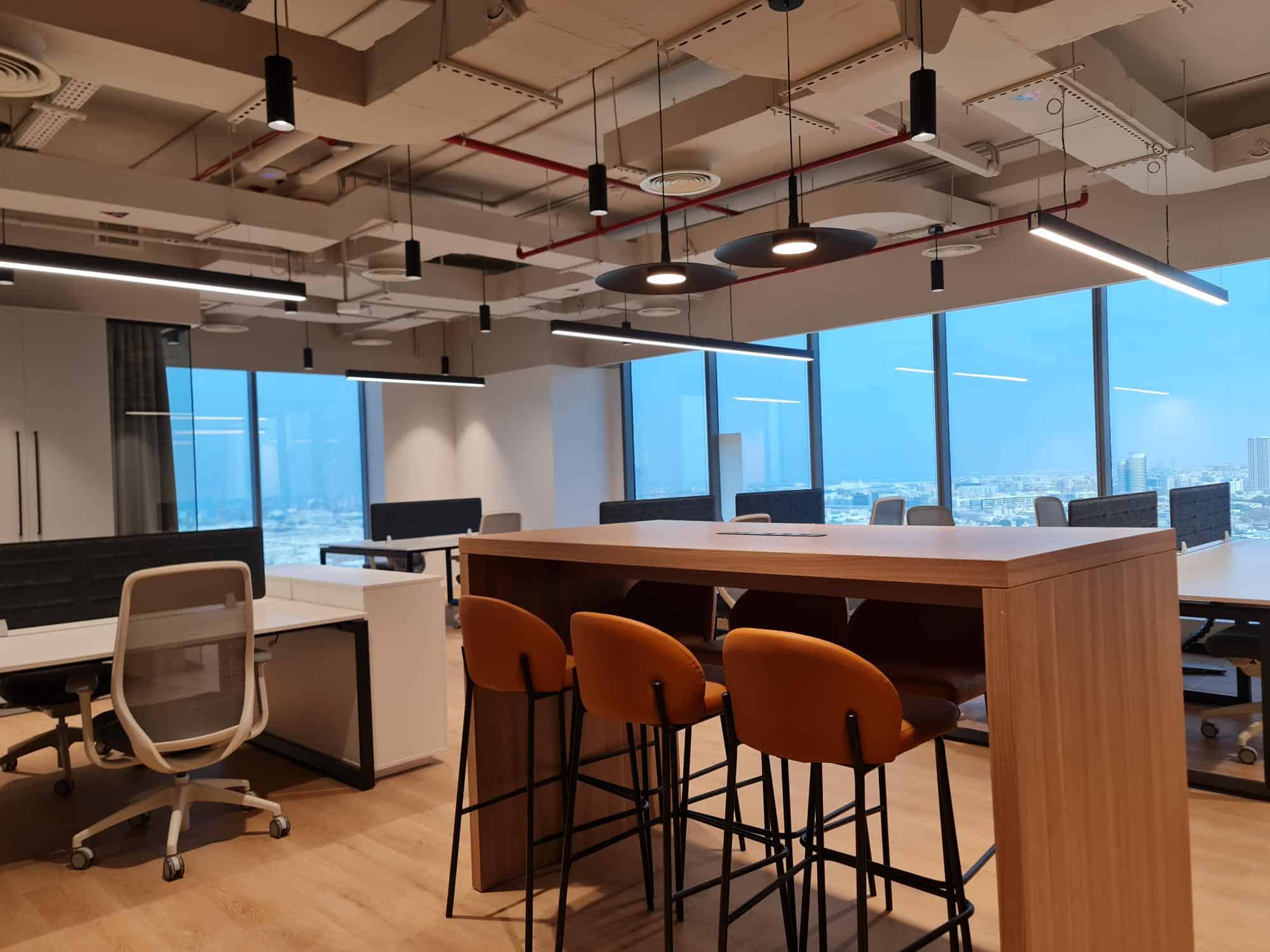 Bright, contemporary workspace with large windows, ergonomic chairs, and stylish lighting for productivity.