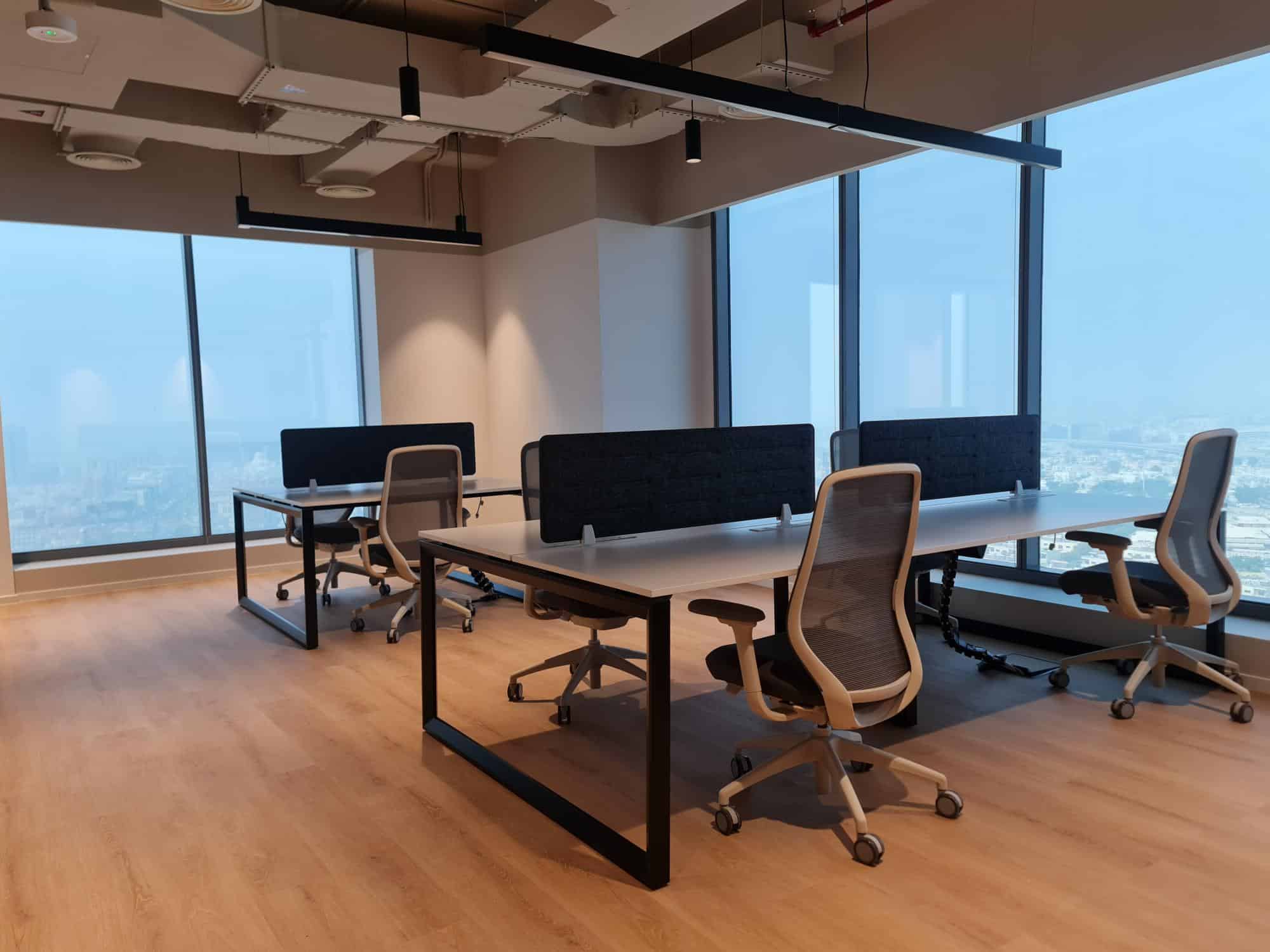 Spacious office with large windows, versatile desks, and comfortable chairs in a top UAE business hub.