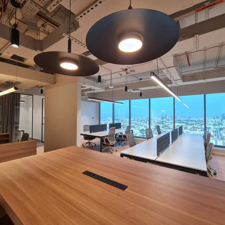 Bright, contemporary workspace in UAE with large windows and innovative lighting design.