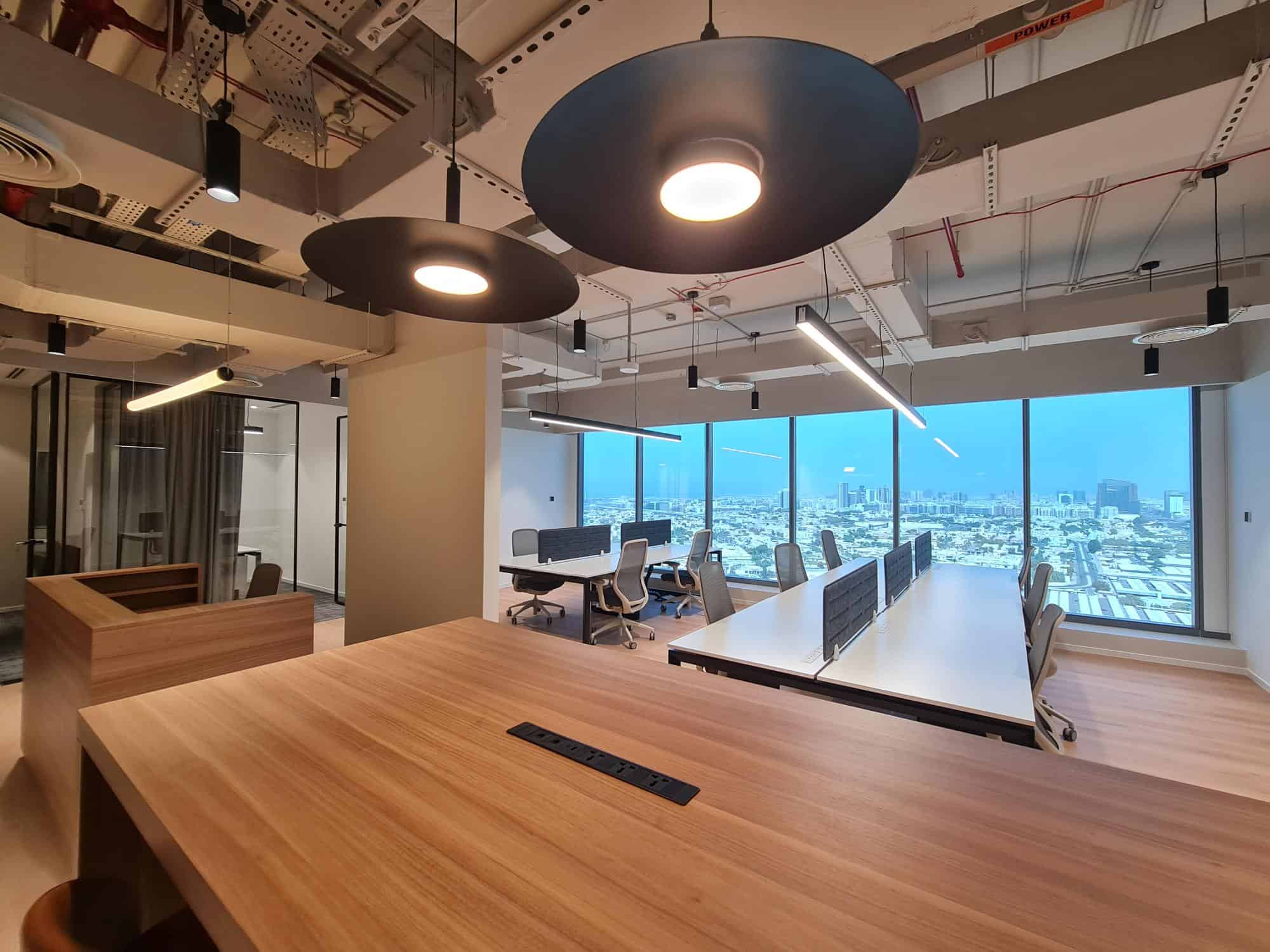 Bright, contemporary workspace in UAE with large windows and innovative lighting design.