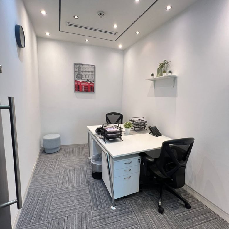 Cozy, minimalistic office interior with white walls, black chairs, and professional workspace setup.