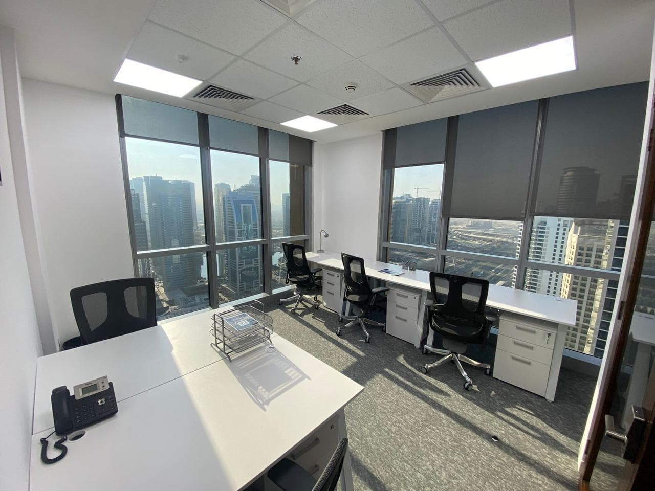 Bright office with large windows and cityscape view in Dubai, ideal for startups and remote teams.