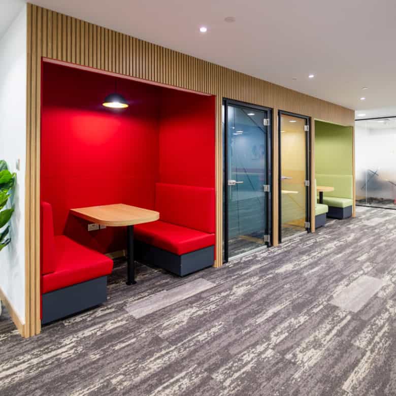 Modern private work booths with colorful seating in a shared office space in Dubai, UAE.
