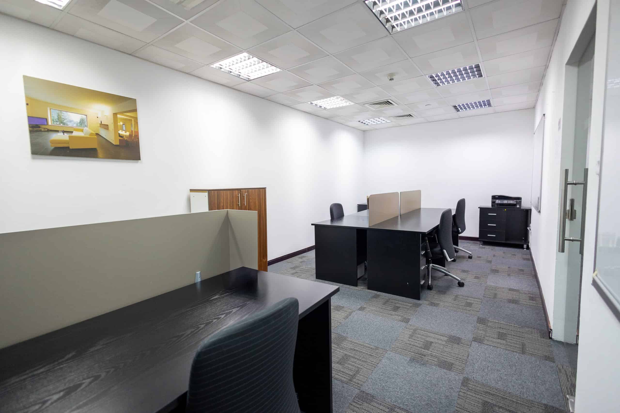 Bright, clean coworking office with desks, chairs, and partition screens in Dubai UAE.