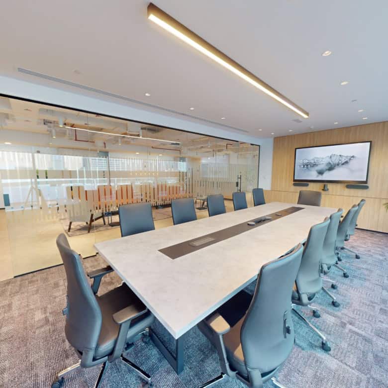 Bright, professional meeting room in UAE with large windows, conference table, and tech setup.
