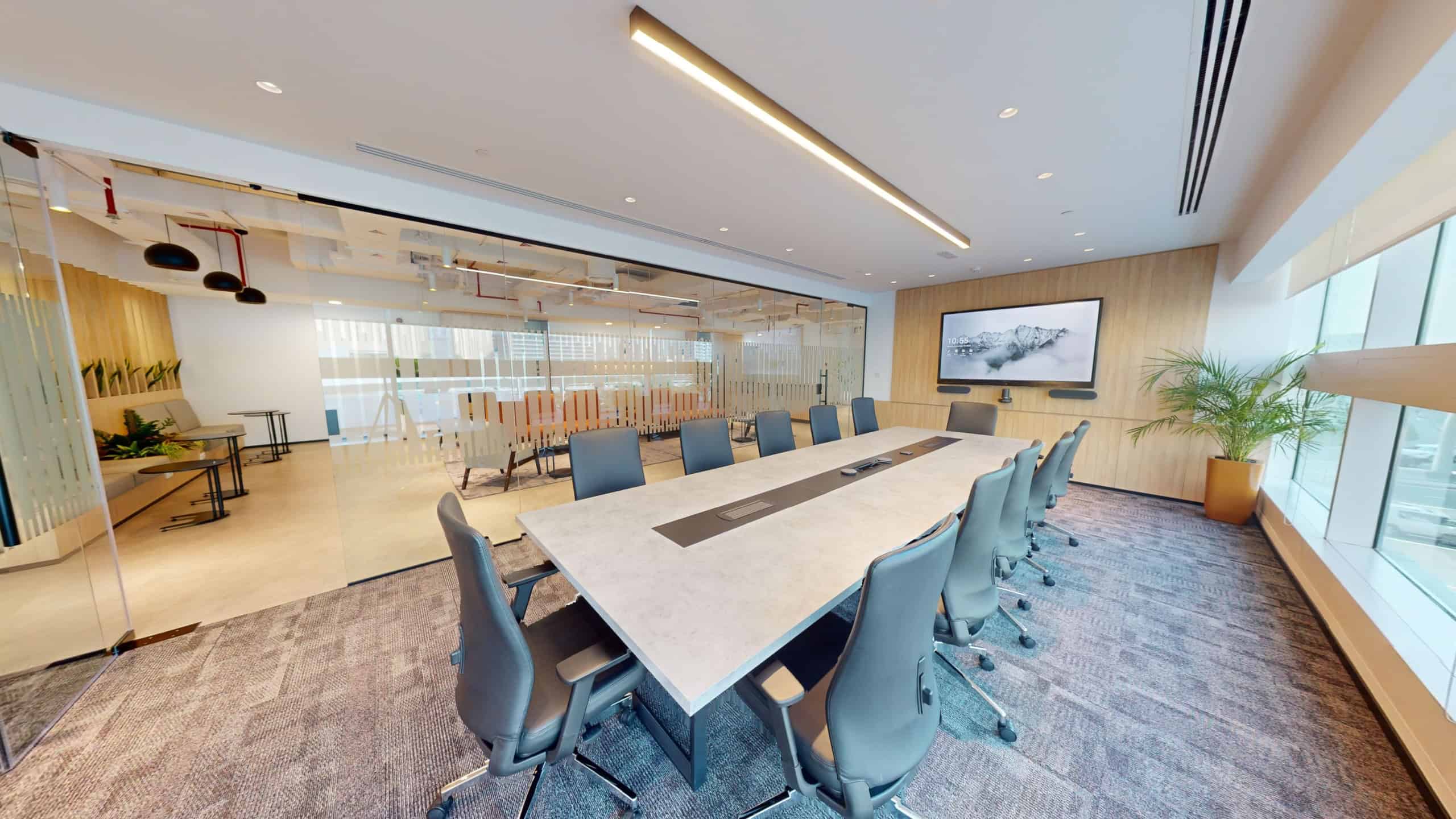 Bright, professional meeting room in UAE with large windows, conference table, and tech setup.