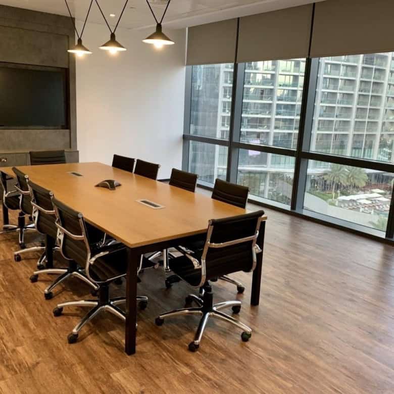 A professional meeting room with stylish furniture, large windows, and panoramic city views in Dubai UAE.