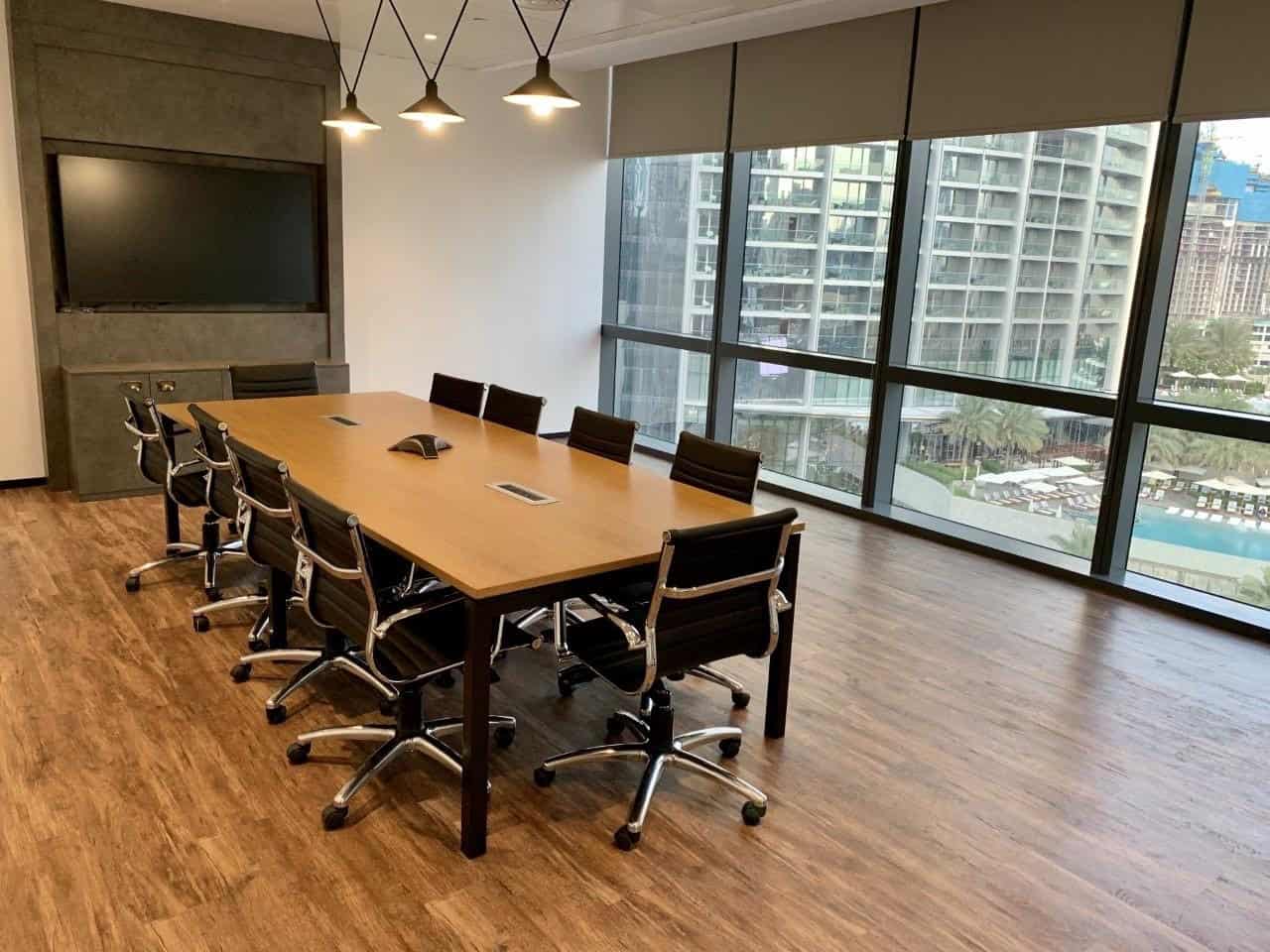 A professional meeting room with stylish furniture, large windows, and panoramic city views in Dubai UAE.