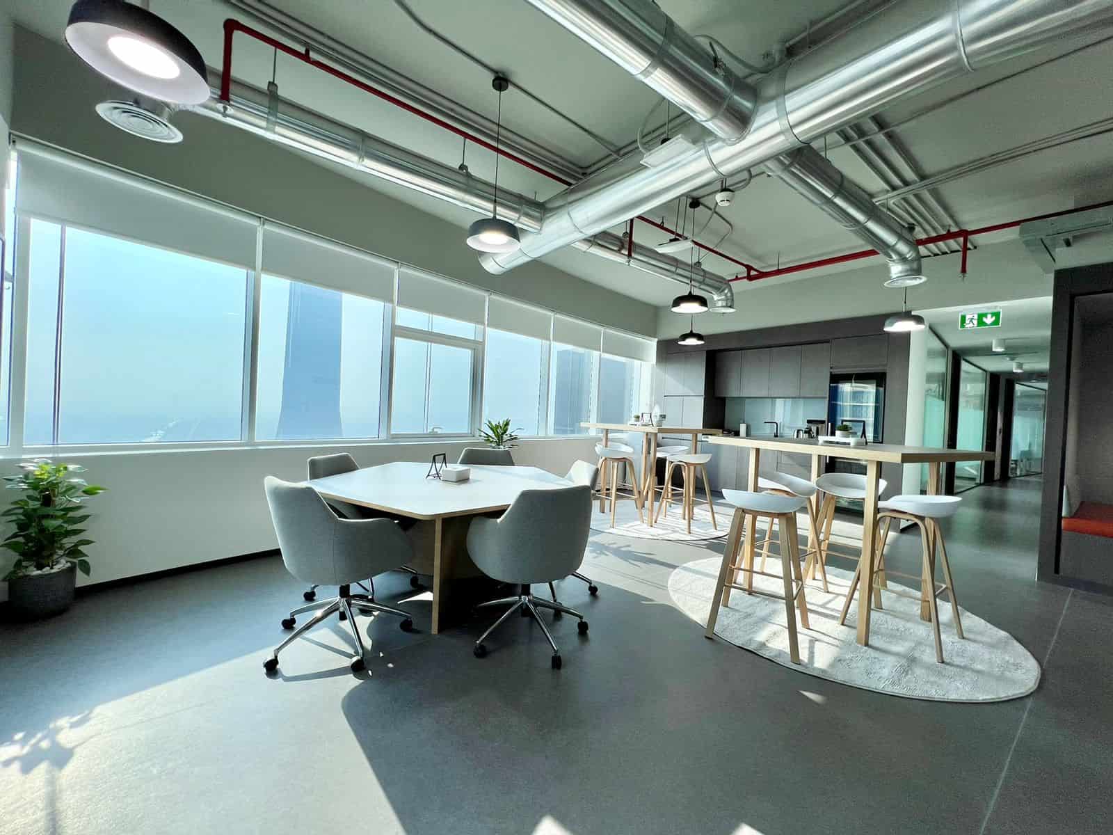 Bright coworking area with large windows, modern seating, and a high-rise city view at Nextspace UAE.