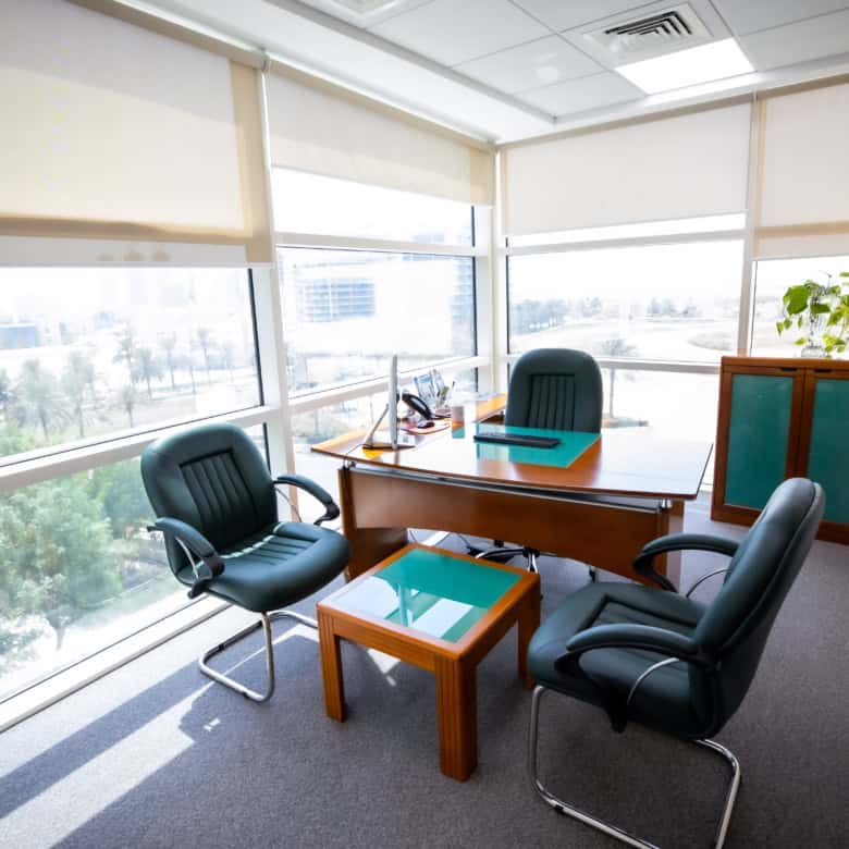Bright UAE coworking space with glass walls and ergonomic furniture.