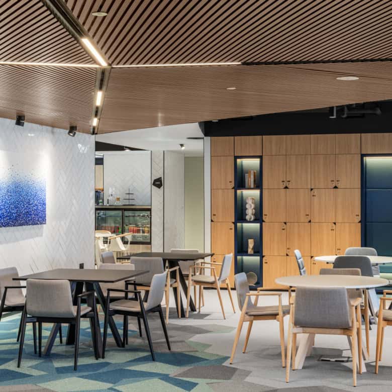 Bright coworking lounge featuring comfortable tables and chairs at Nextspace UAE.